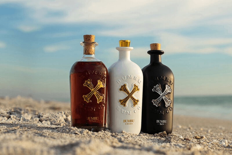 Bumbu rum bottles - The Original, Crème and XO - on a beach